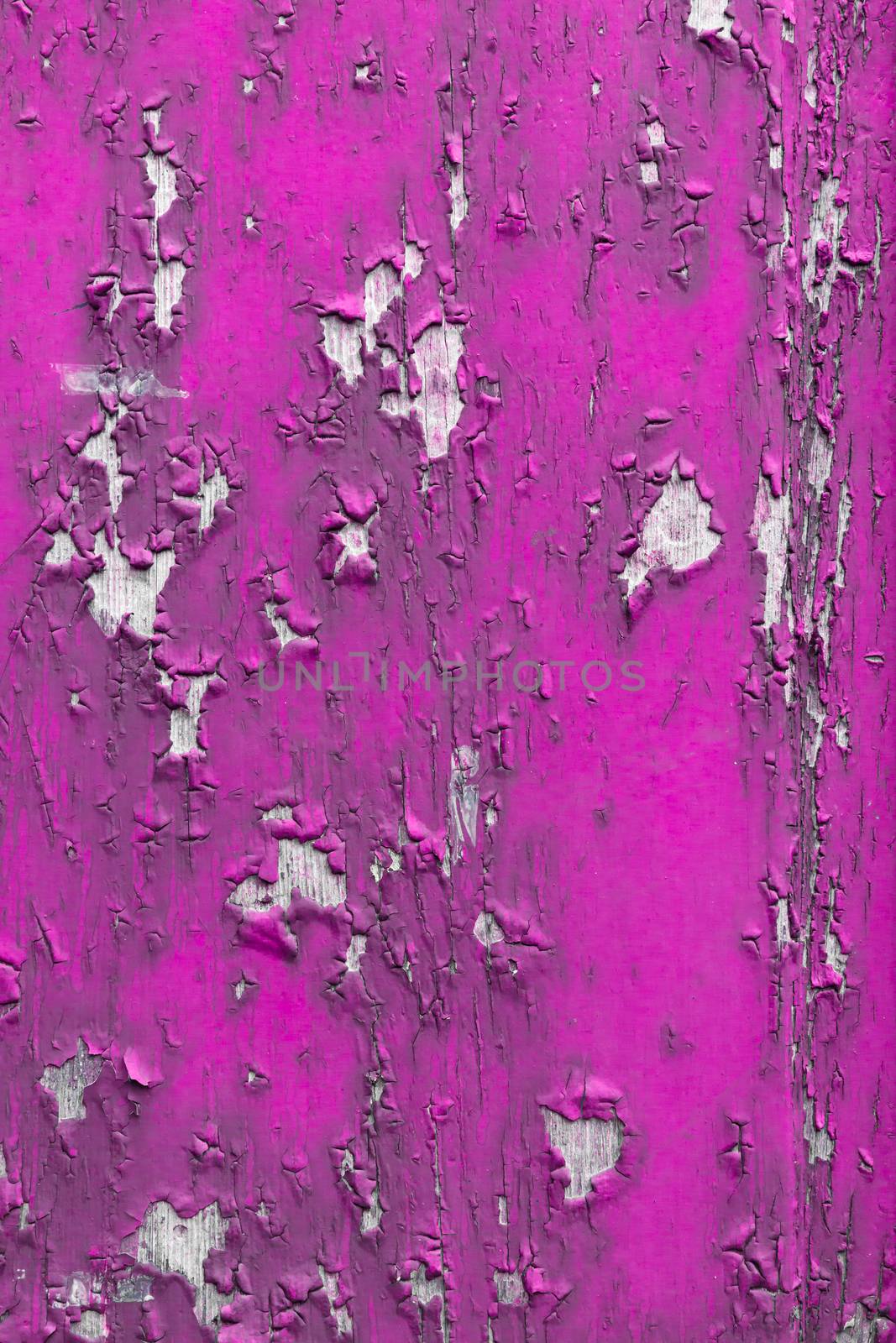 A wooden surface, painted pink with obvious signs of cracking and peeling paint.