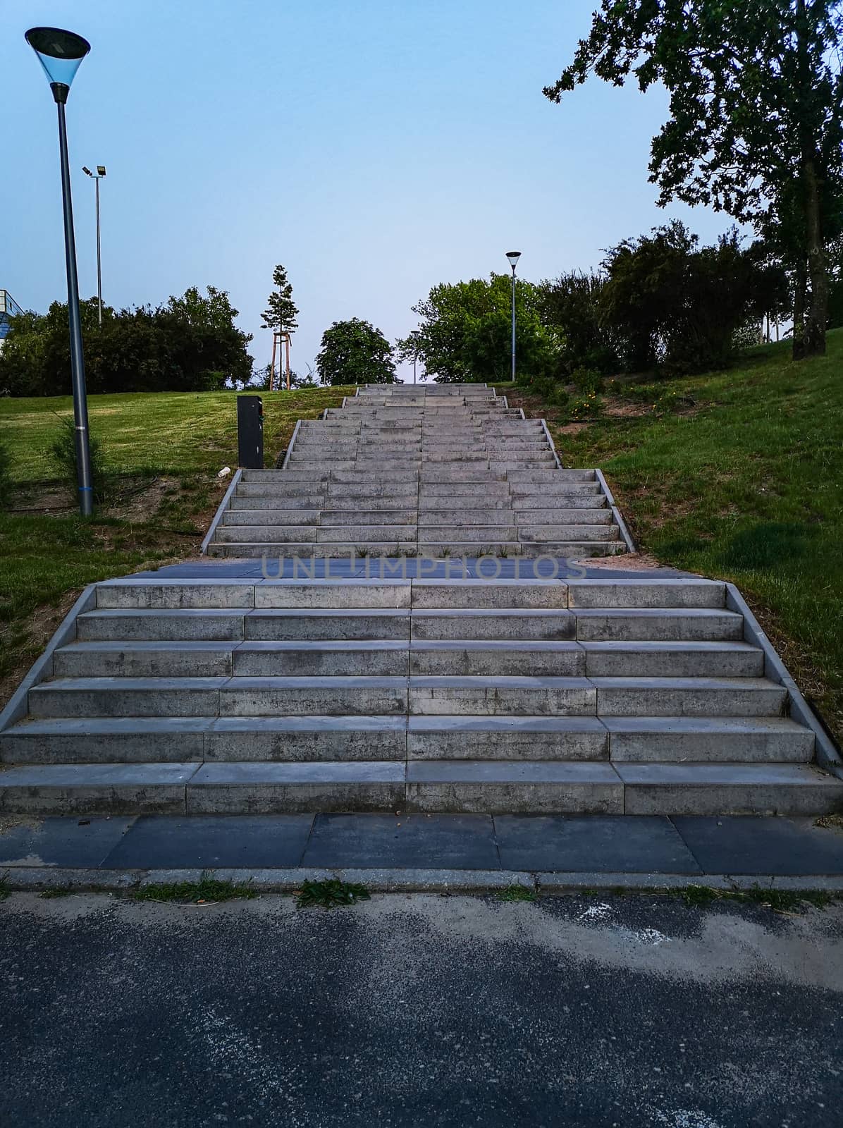 Concrete high wide stairs to path in park by Wierzchu