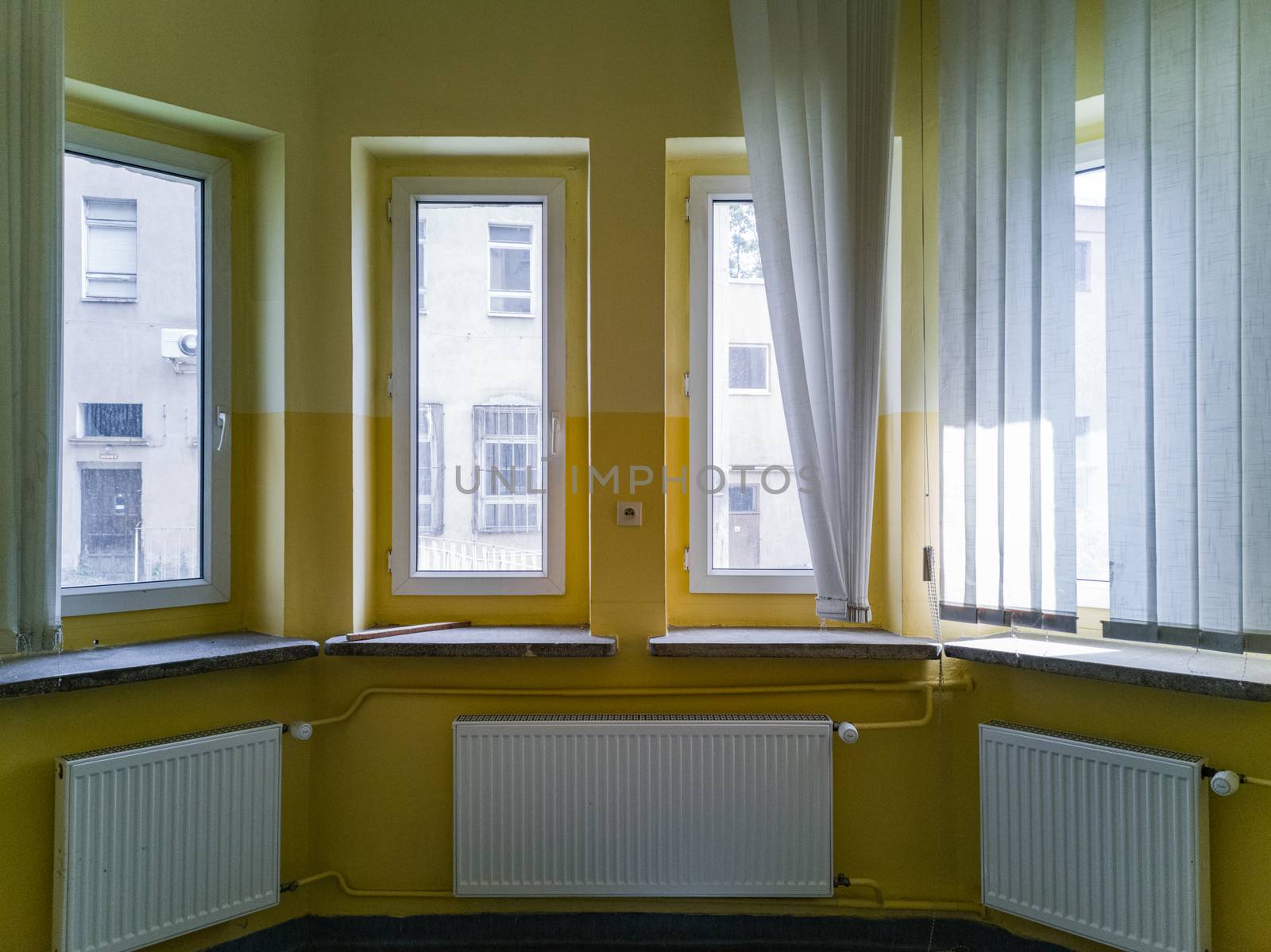 Round wall full of windows and radiators in old abandoned hospital by Wierzchu