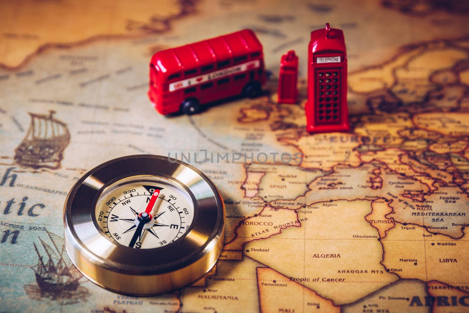 The iconic red bus and Big Ben miniature with compass on the map of London, UK. Concept of travel.
