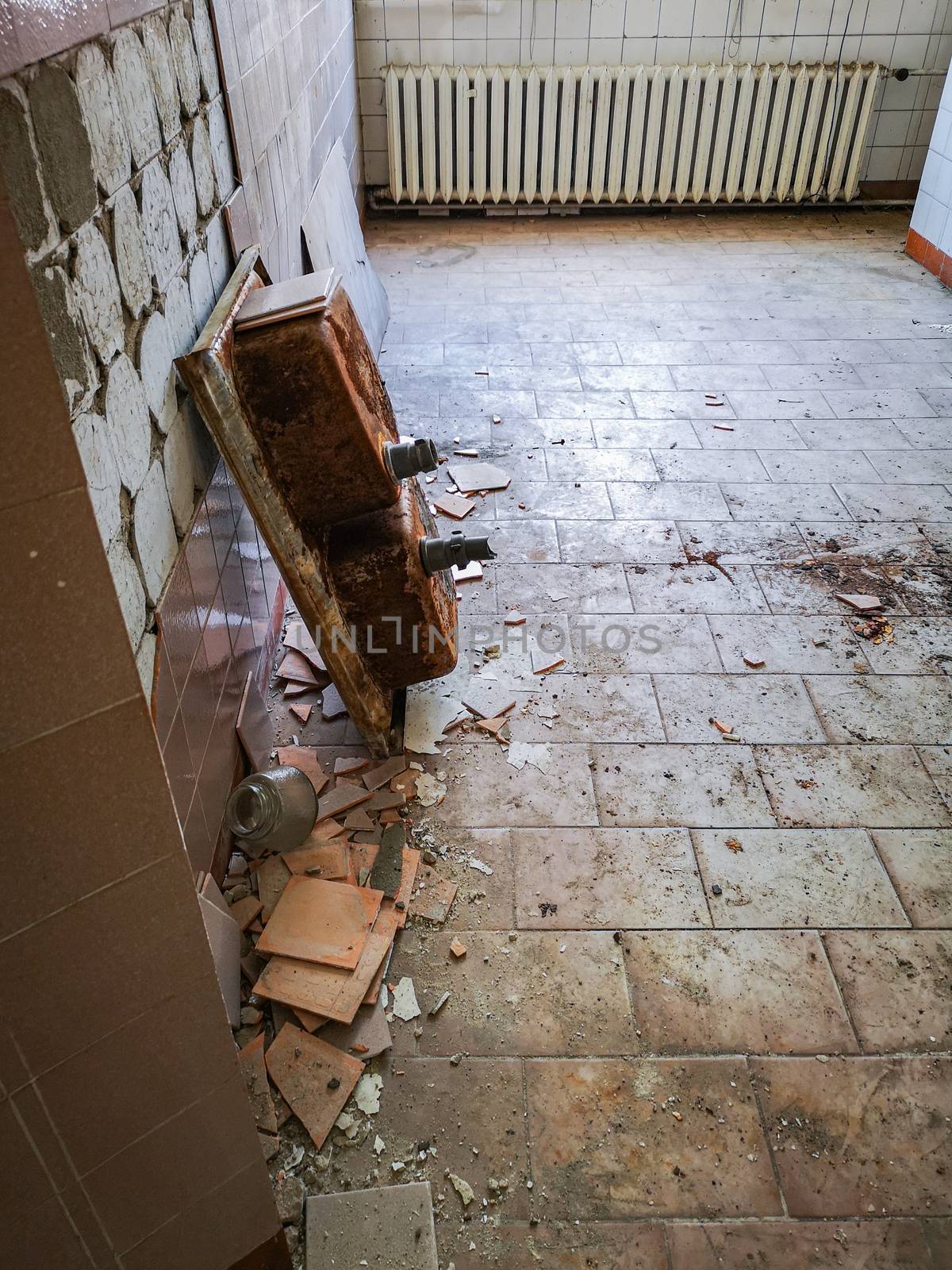 Old rusty double washbasin in old abandoned hospital