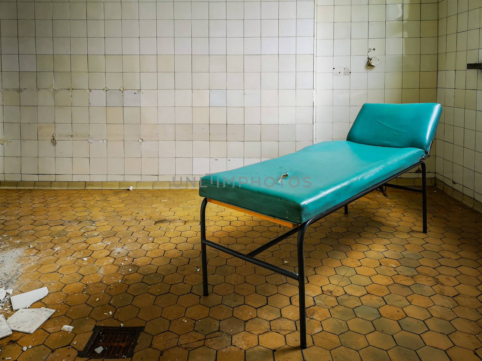 Old hospital bed standing in empty room in old abandoned hospital