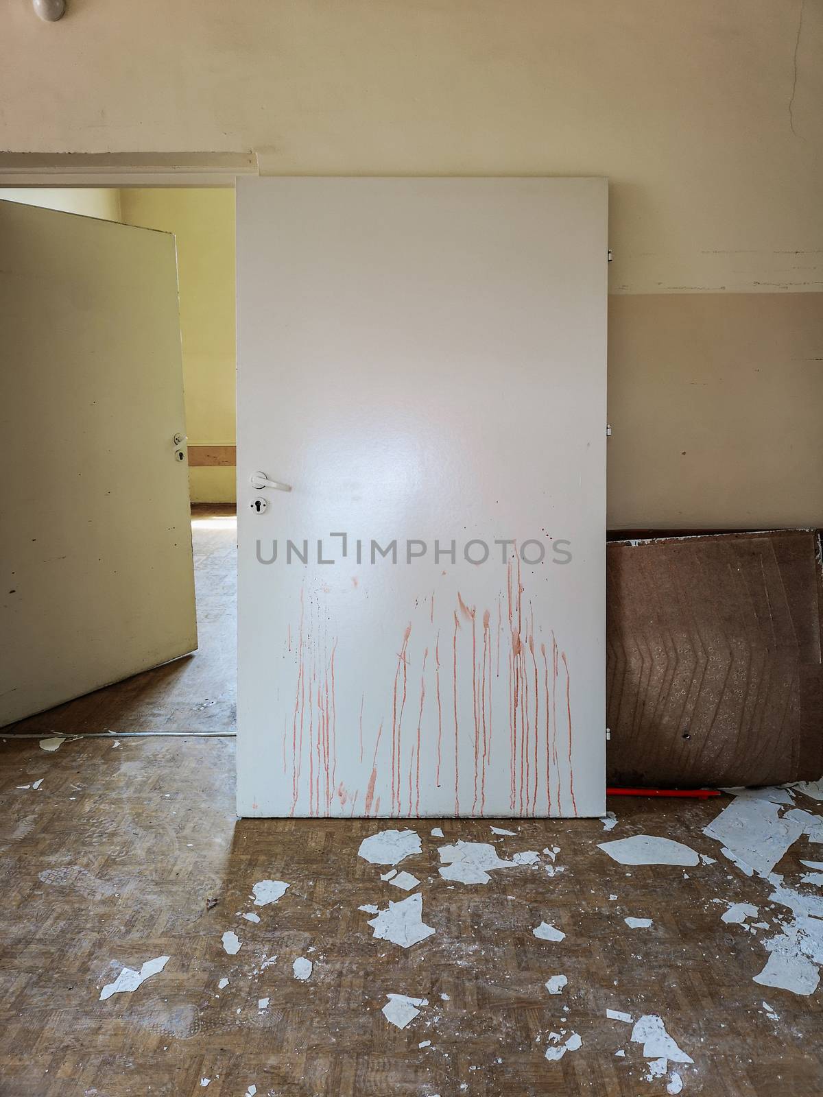 Door removed from the frame with dried blood paths on it in old abandoned hospital