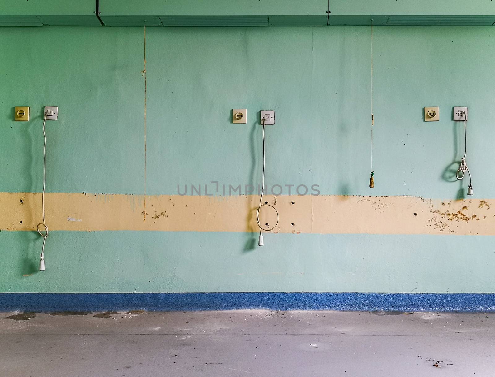 Cables hanged against the wall with bell switches in old abandoned hospital