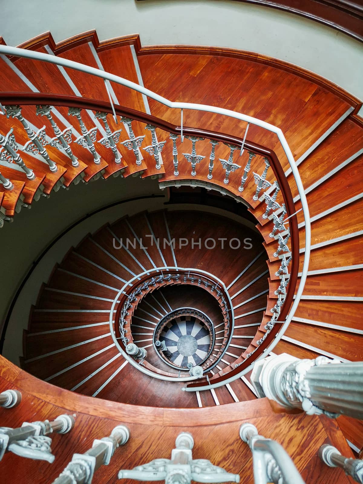 Top down look to Old spiral staircase with ornaments in tenement house 