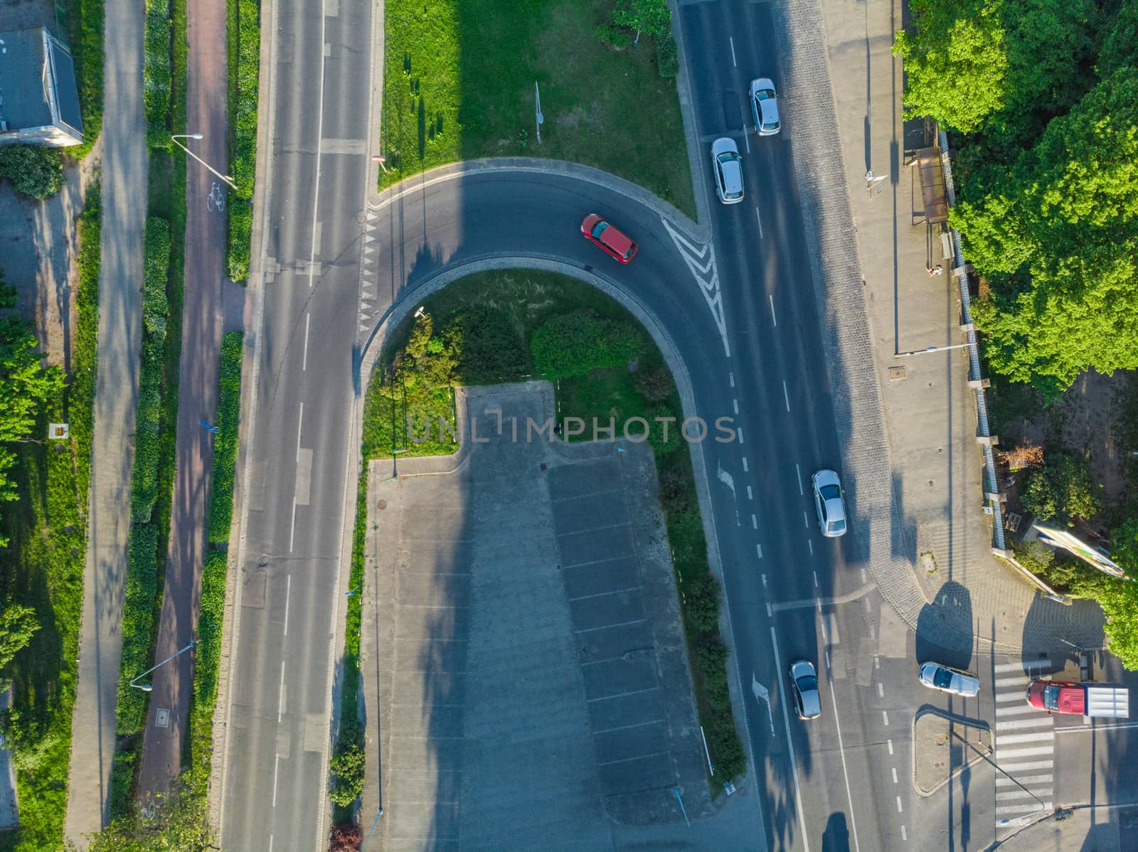 Aerial view to long city streets with few cars buildings and long shadows at sunset by Wierzchu