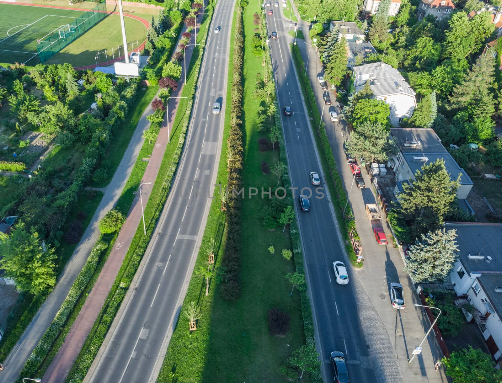 Aerial view to long city streets with few cars buildings and long shadows at sunset by Wierzchu