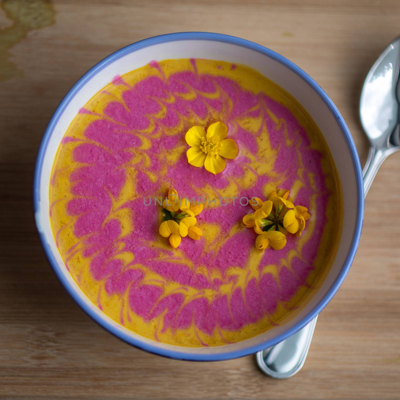 Vegetarian cream pumpkin and beet mix soup decorated with fresh yellow flowers delicious and healthy food