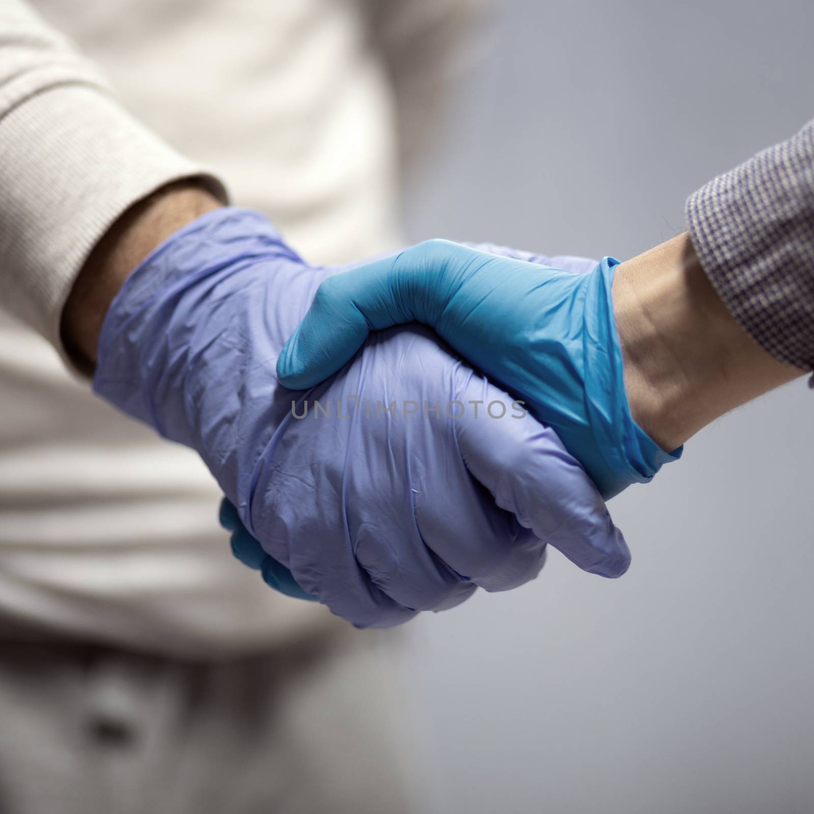 Handshaking with blue protective gloves by adamr