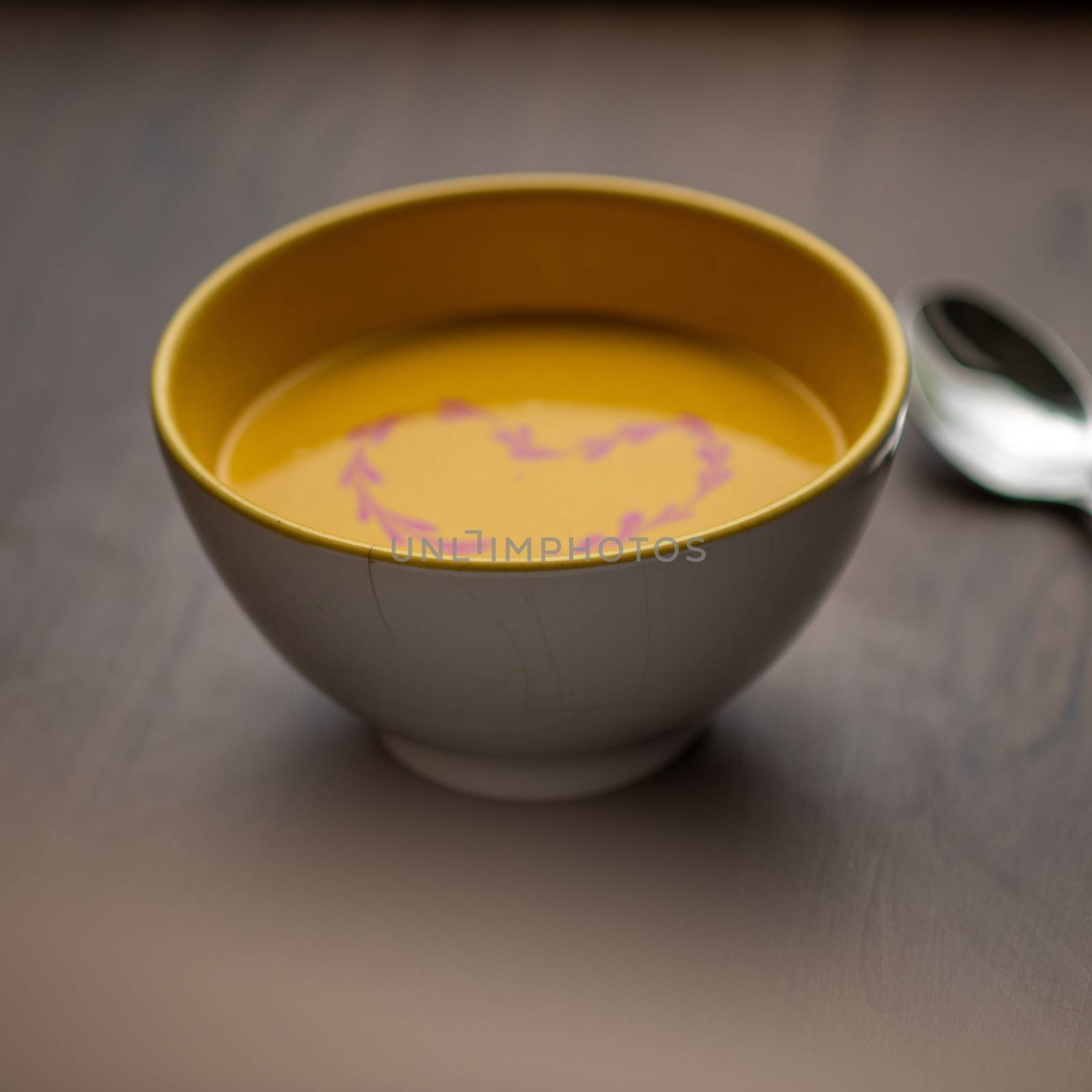 Vegetarian autumn - Pumpkin cream soup with hearth decoration on wooden table