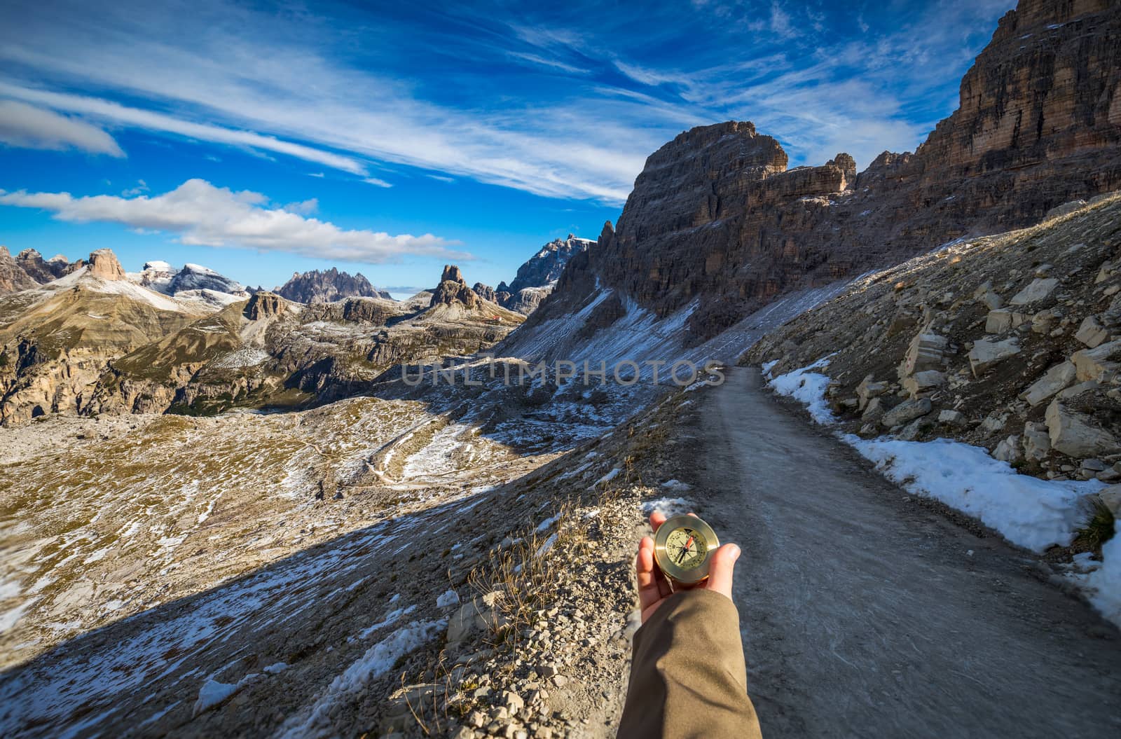 Explorer searching direction with compass in summer mountains, point of view.