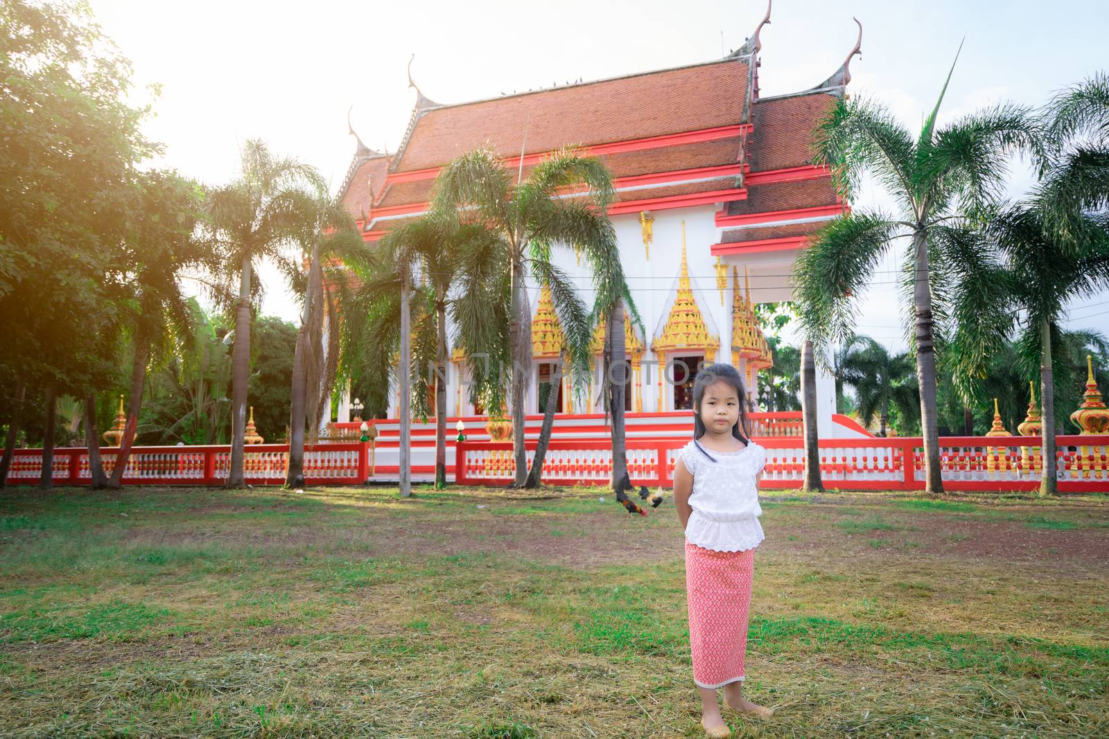 happy asian little girl in Thai period dress standing in the temple