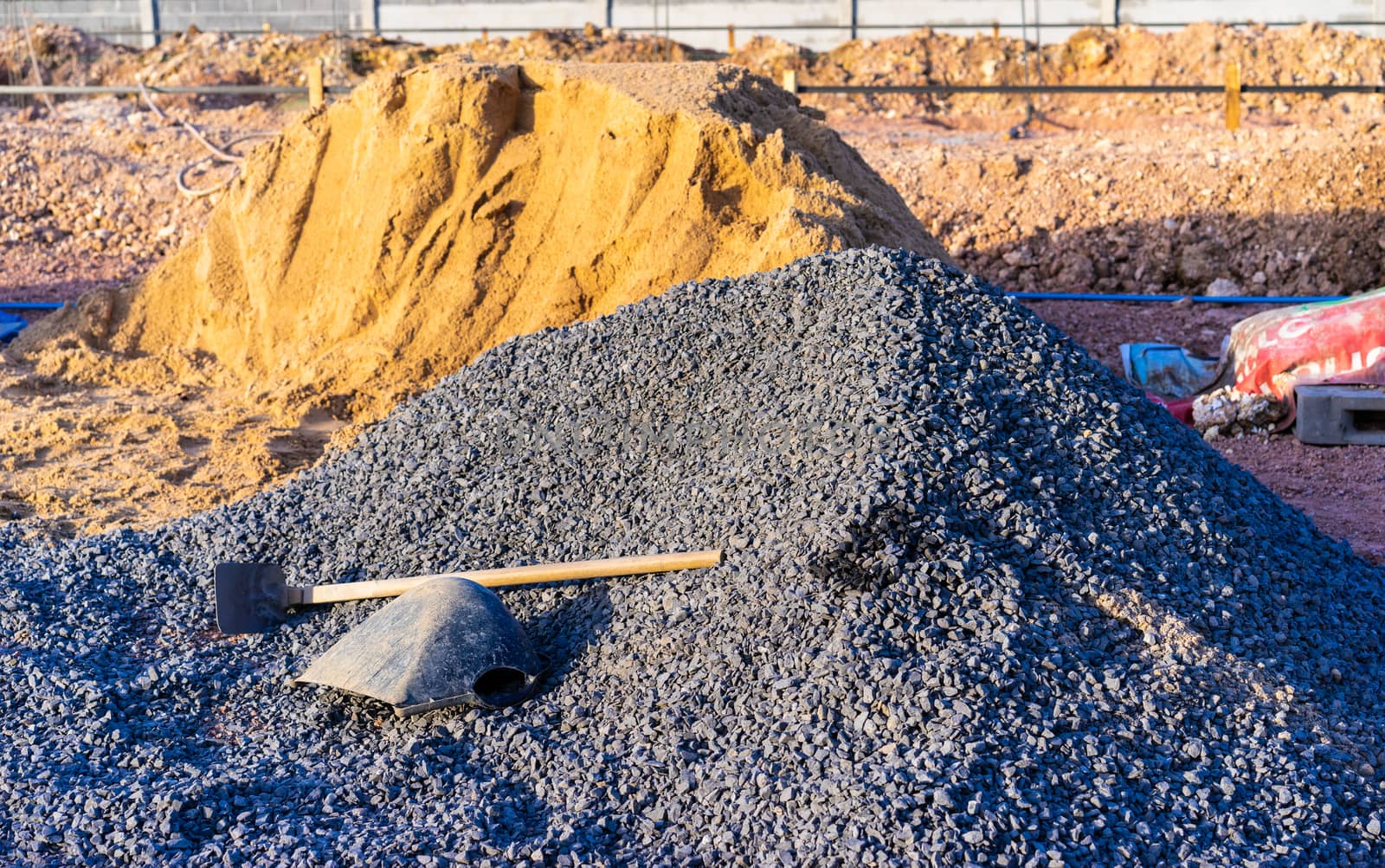 Hoe and buckets on a rock pile in construction