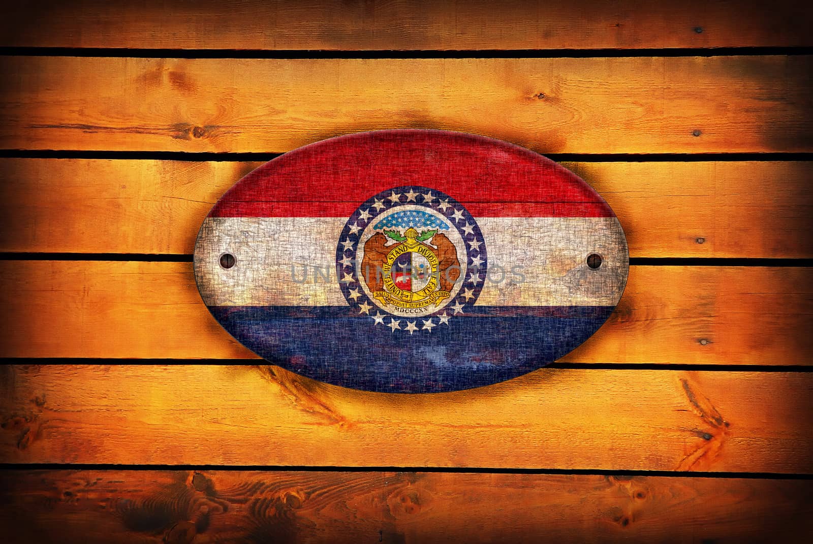 A Missouri flag on brown wooden planks.