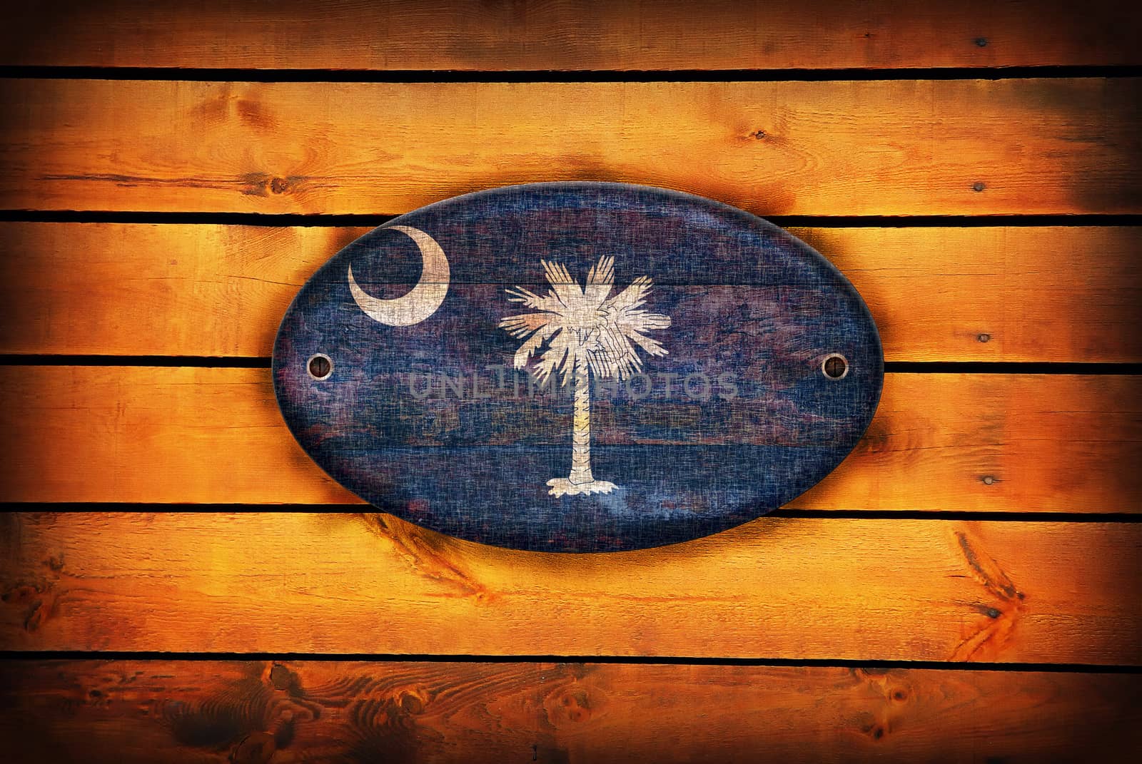 A South Carolina flag on brown wooden planks.
