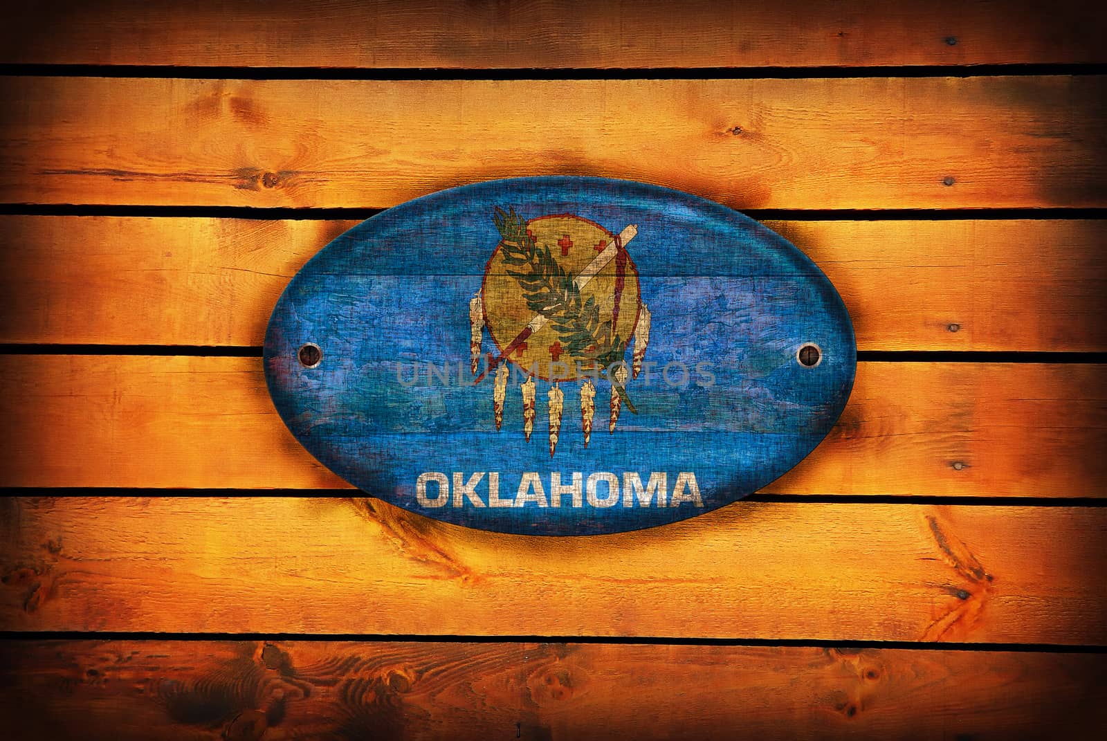 A Oklahoma flag on brown wooden planks.