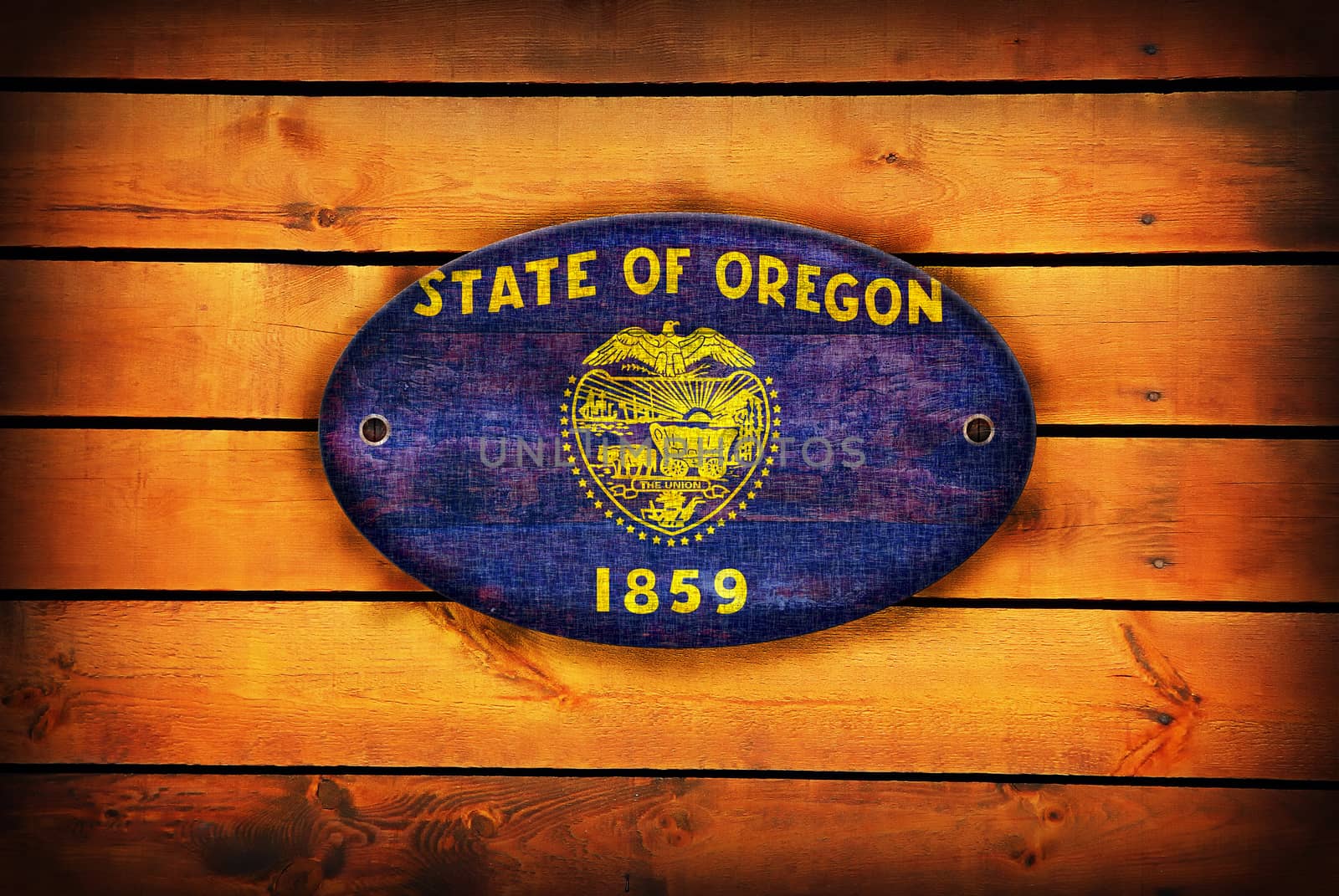 A Oregon flag on brown wooden planks.