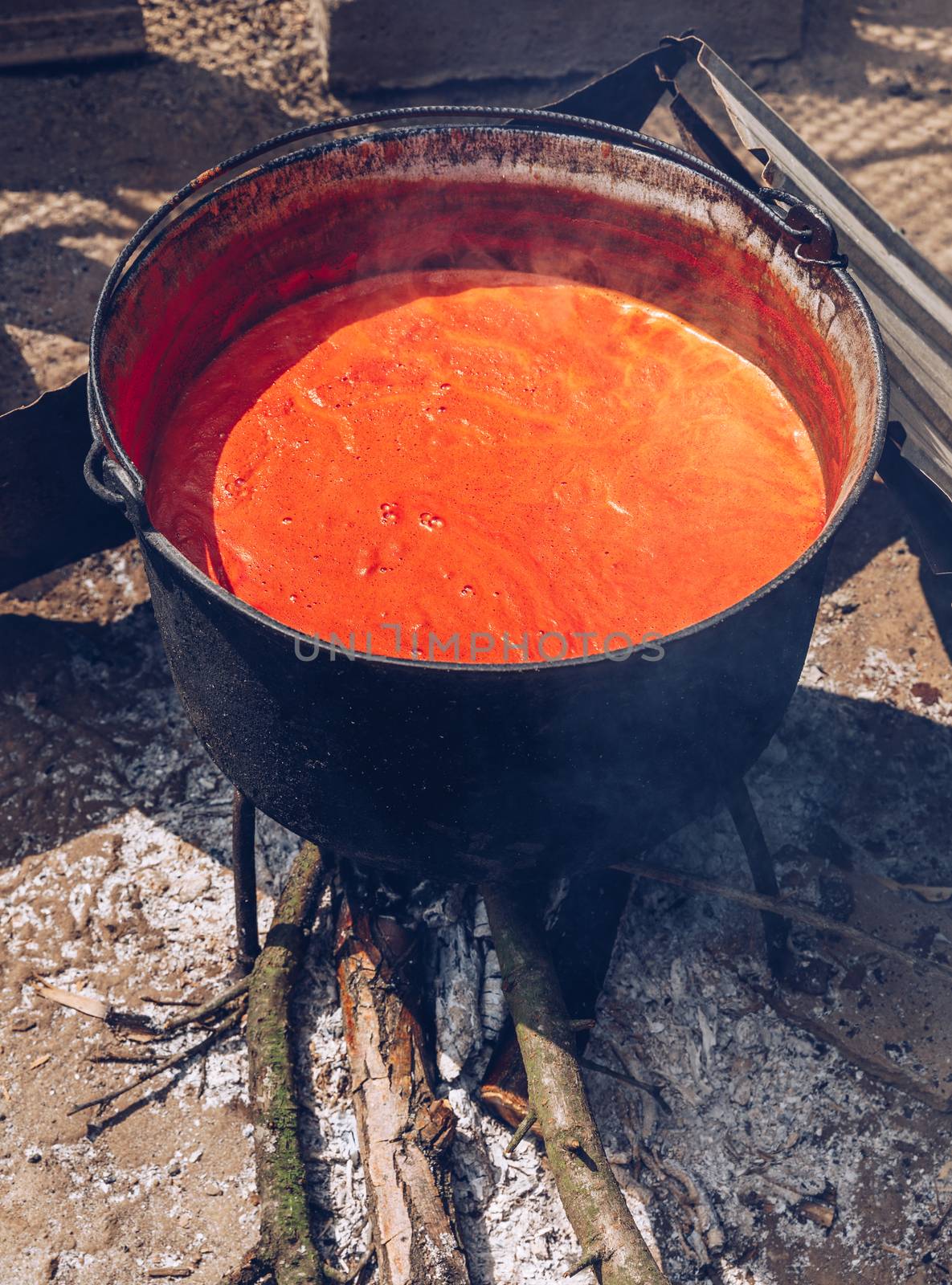 Preparing traditional romanian tomato juice/sause in caldron, boiled and preserved for the winter in a jar.
