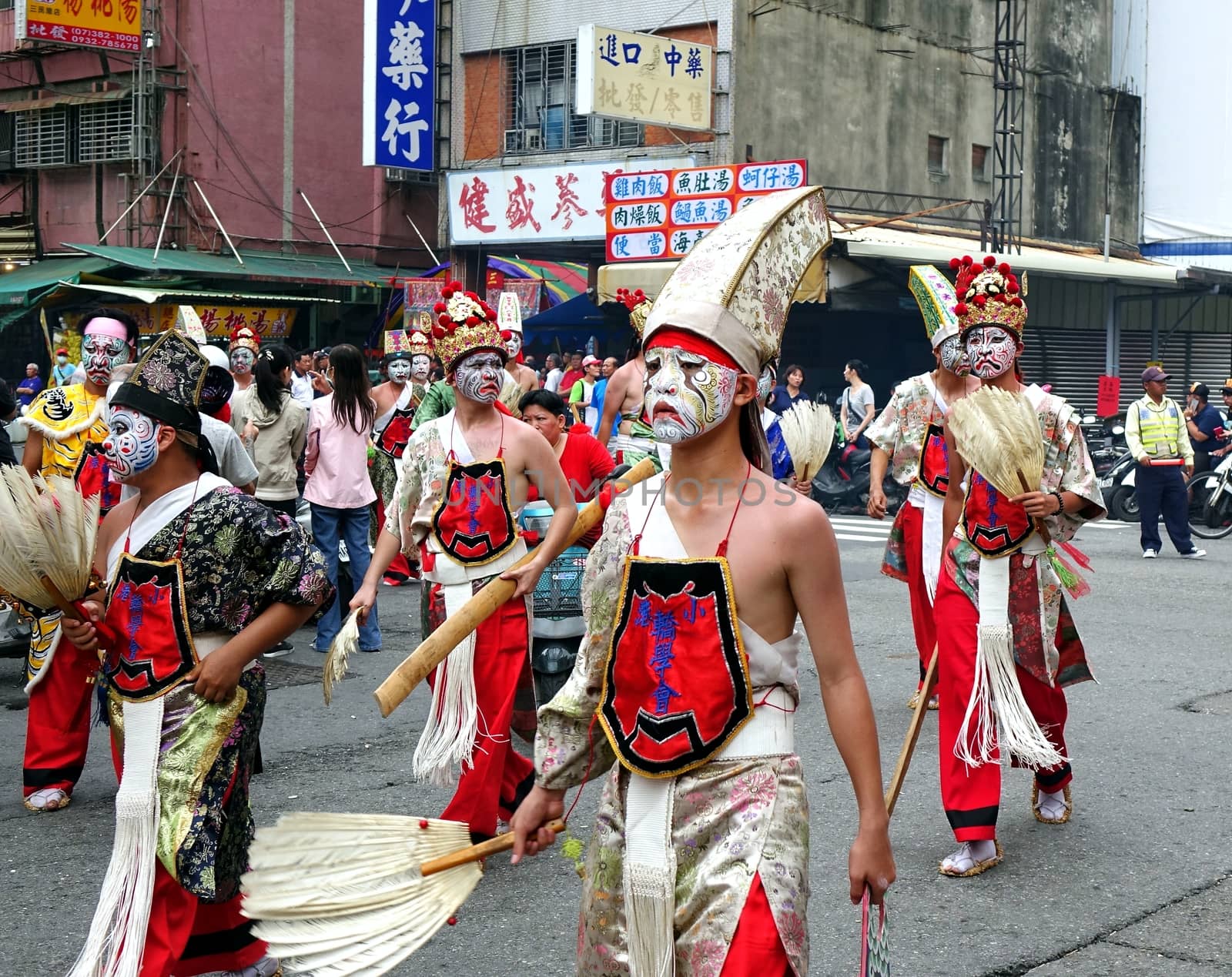 KAOHSIUNG, TAIWAN -- JULY 9, 2016: Young men in traditional costumes and painted facial masks take part in a local temple ceremony.

