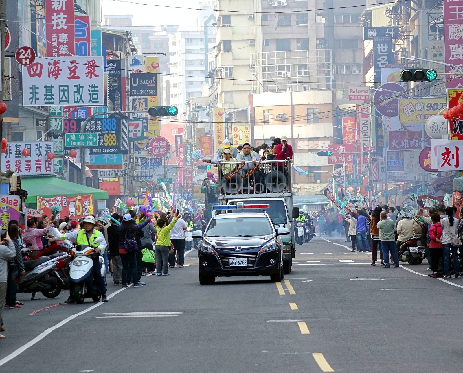 KAOHSIUNG, TAIWAN -- JANUARY 9, 2016: Supporters of DPP presidential candidate Tsai Ying-Wen welcome her motorcade with flags and firecrackers during a campaign event.