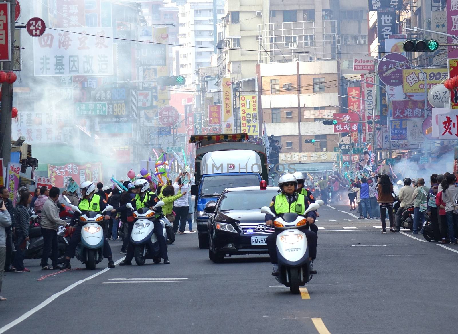 KAOHSIUNG, TAIWAN -- JANUARY 9, 2016: Supporters of DPP presidential candidate Tsai Ying-Wen welcome her motorcade with flags and firecrackers during a campaign event.