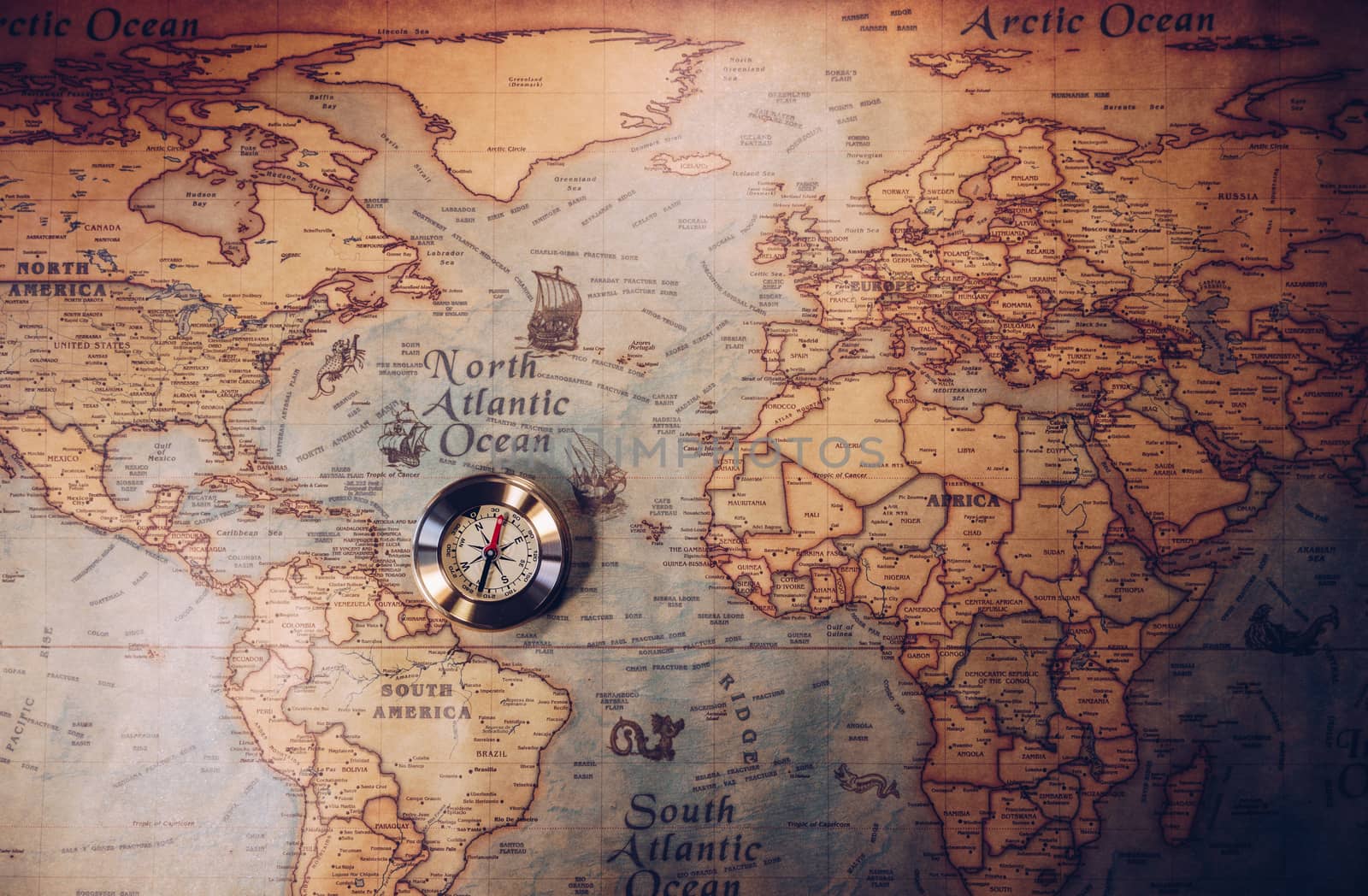 Old vintage retro golden compass on ancient map. Selective focus, shallow depth of field. Concept of world travel, sightseeing and tourism.
