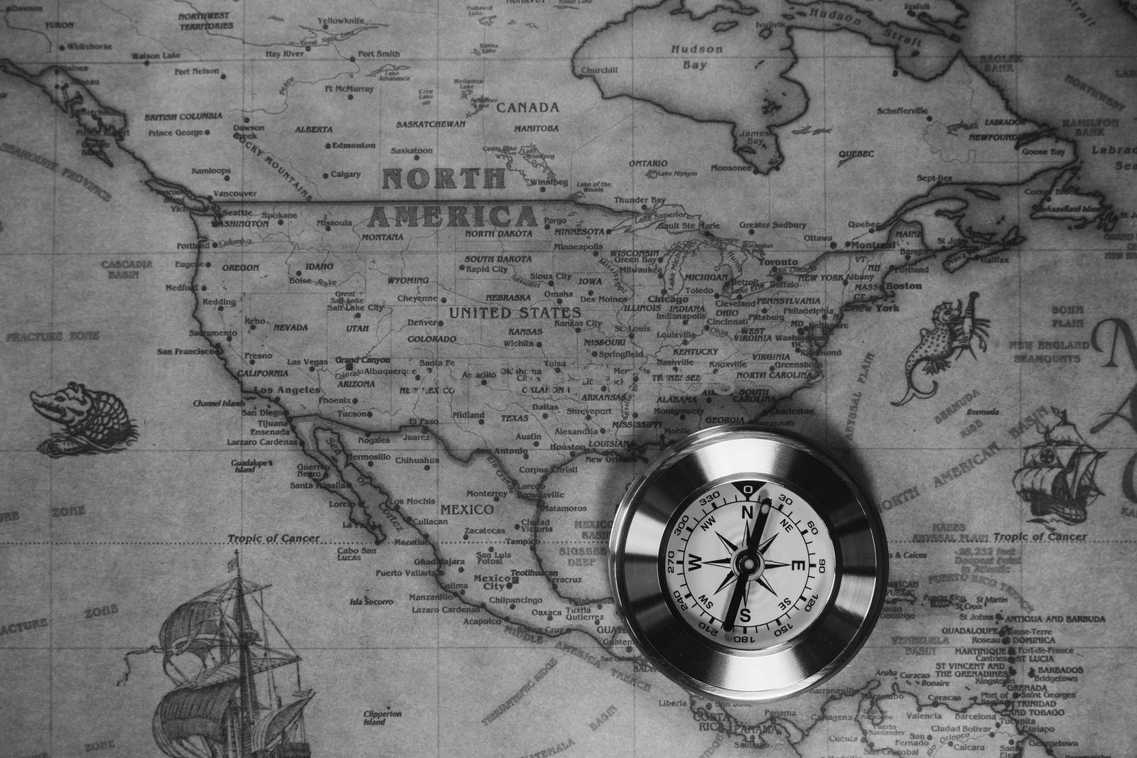 Old compass on vintage map. Adventure stories background. Retro style. The map used for background is in Public domain. Map source: Library of Congress. Country: Belgium Year: 1570. Author: Abraham Ortelius (1527-1598)