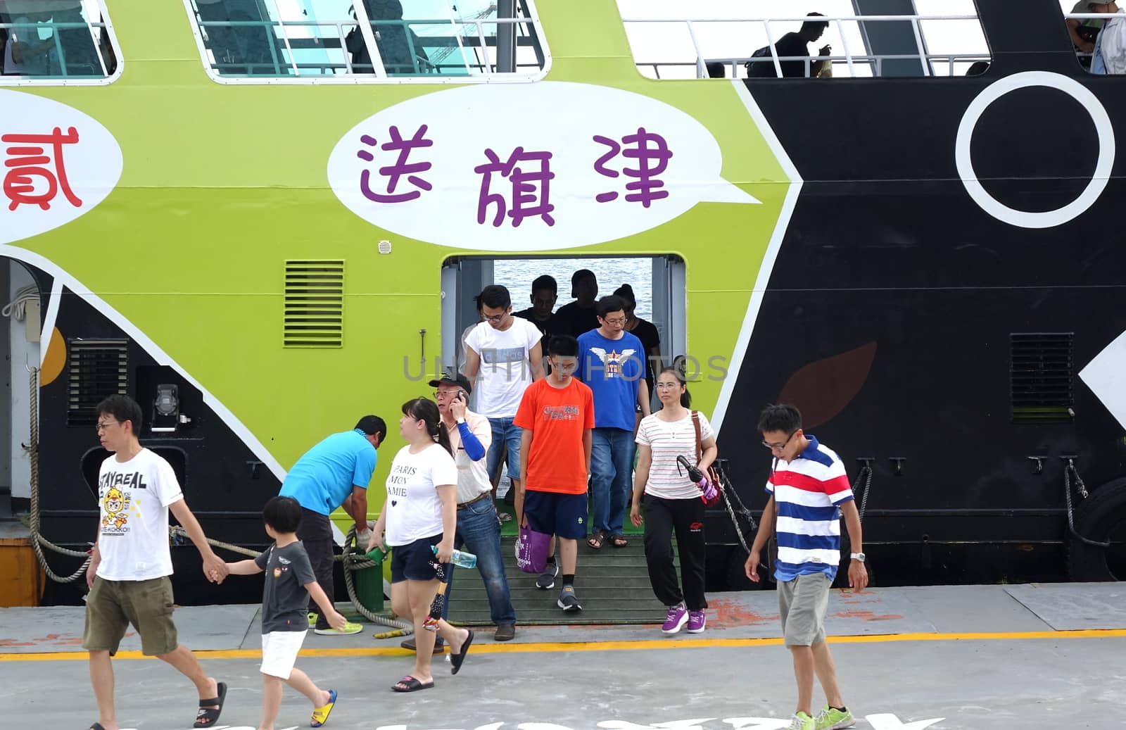 KAOHSIUNG, TAIWAN -- JUNE 30, 2018: Passengers disembark from the new cross-harbor ferry which is powered by electricity and features the popular black bear mascot.
