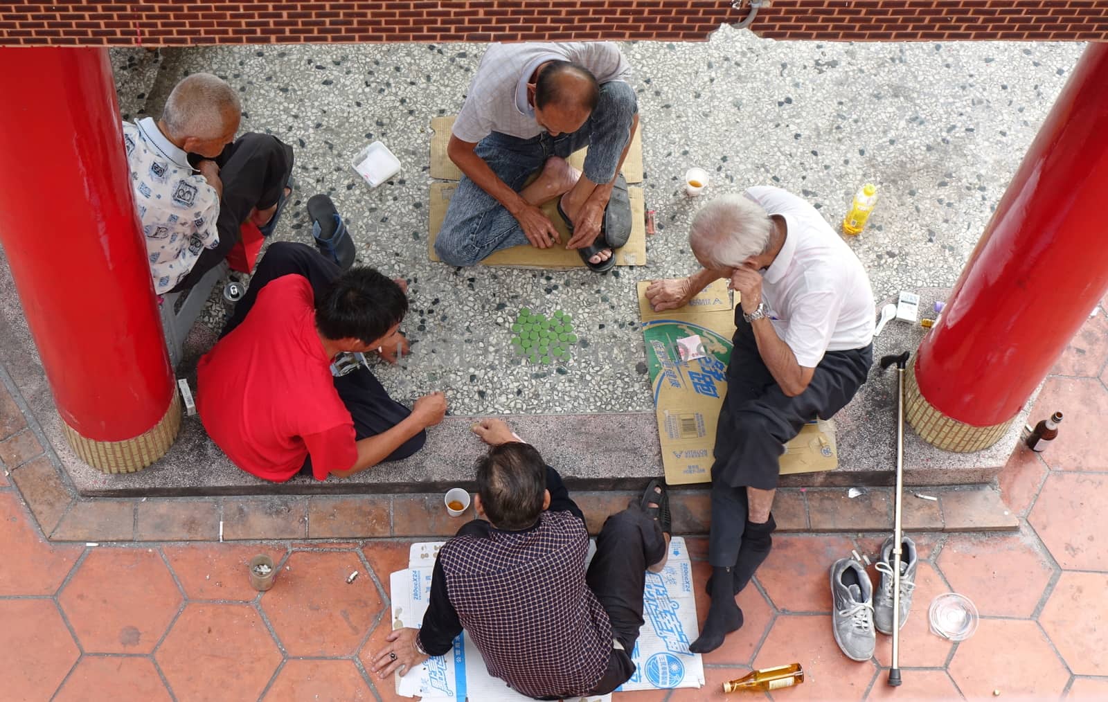 KAOHSIUNG, TAIWAN -- OCTOBER 19, 2018: Four elderly men play checkers under the roof of a local temple.
