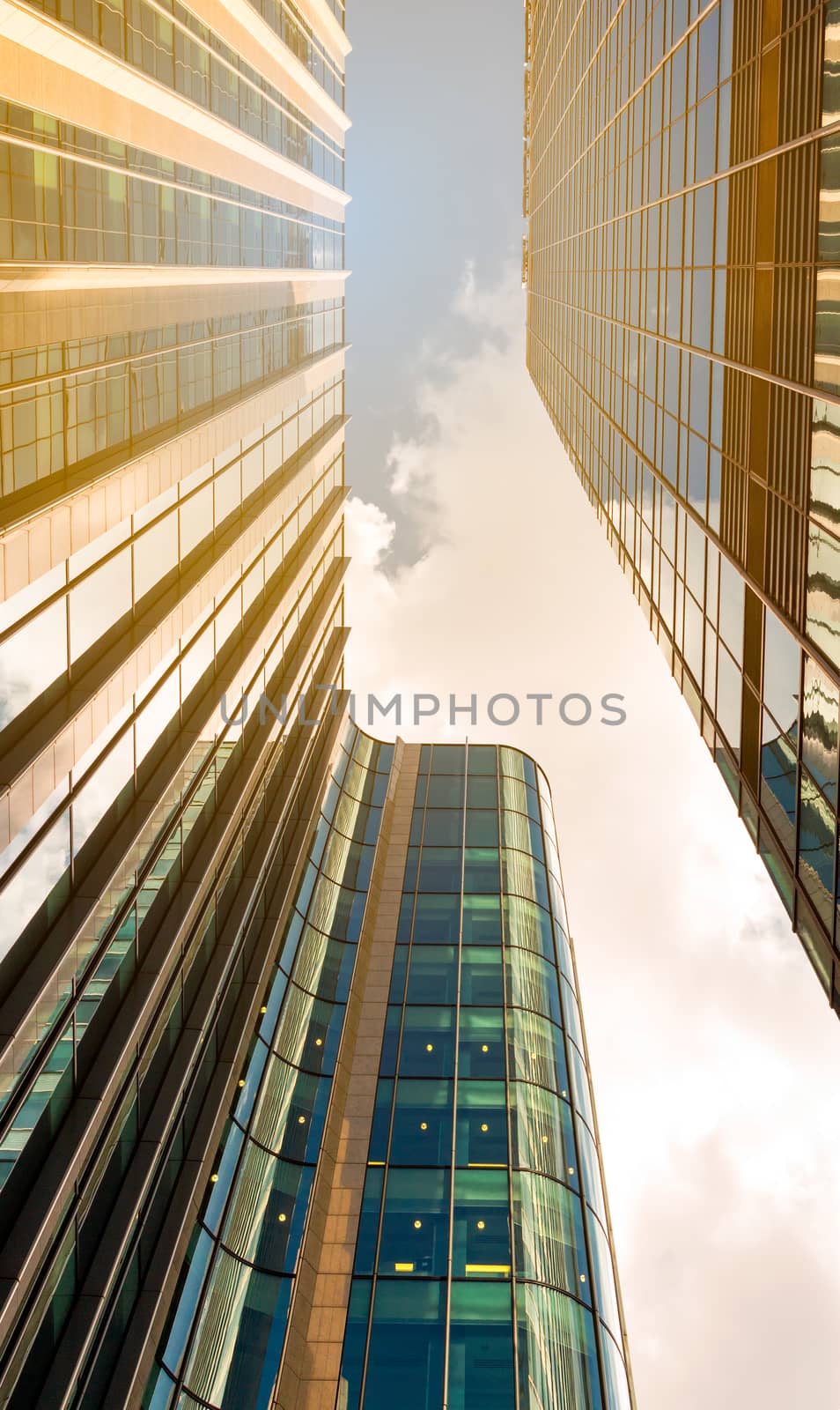 Bottom view of modern skyscrapers in business district against blue sky