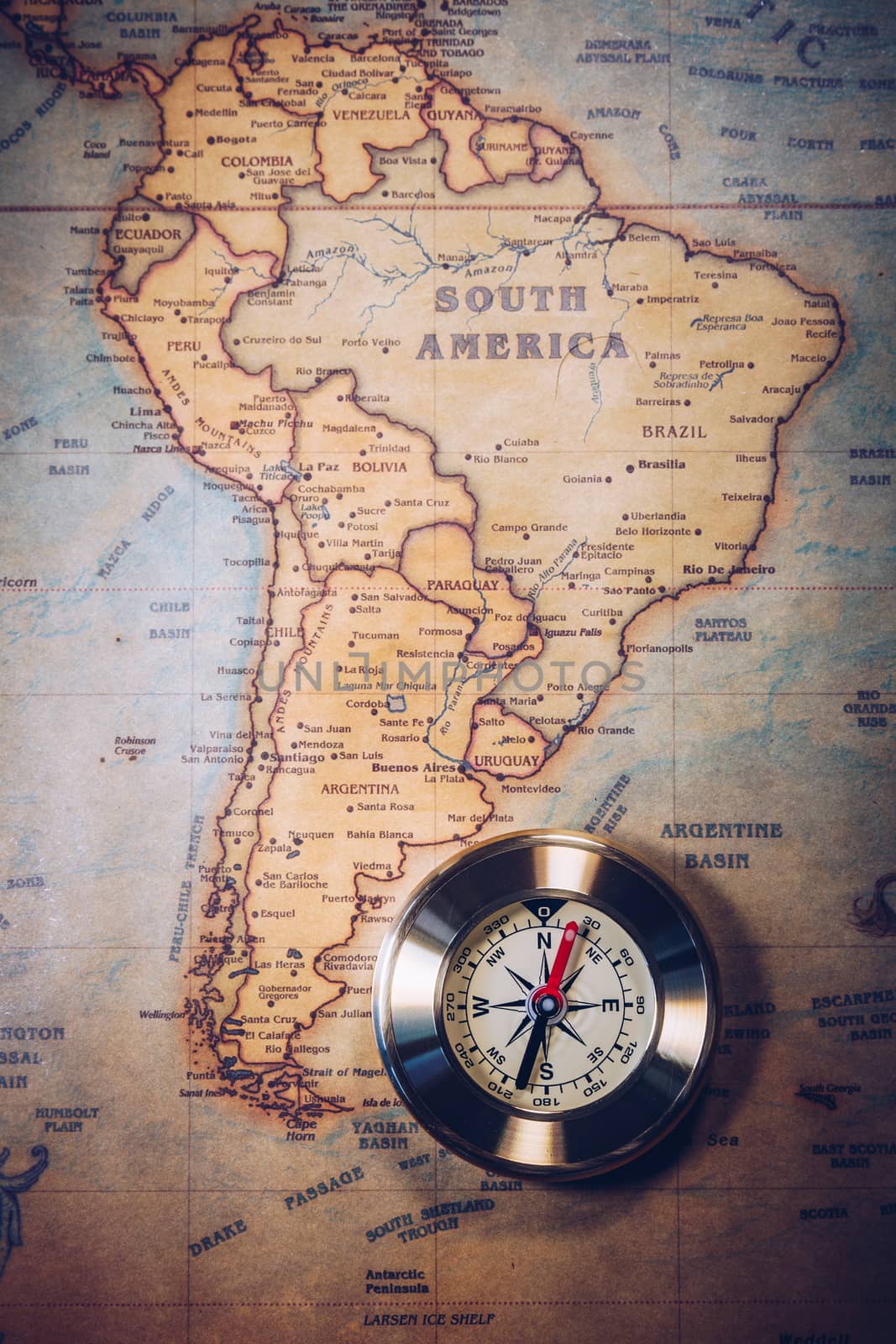 Old vintage retro golden compass on ancient map. Selective focus, shallow depth of field. Concept of world travel, sightseeing and tourism.