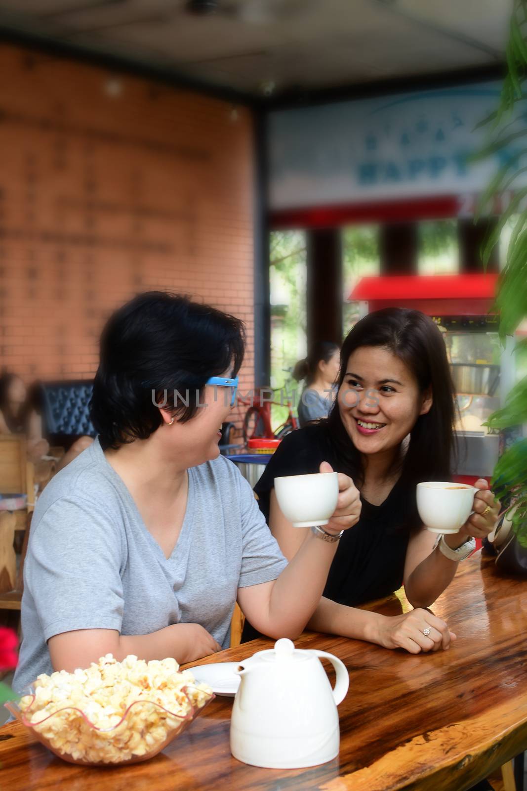 Best friends beautiful asian women drinking coffee and tea with popcorn have a friendship in talking and chatting in cafe coffee shop