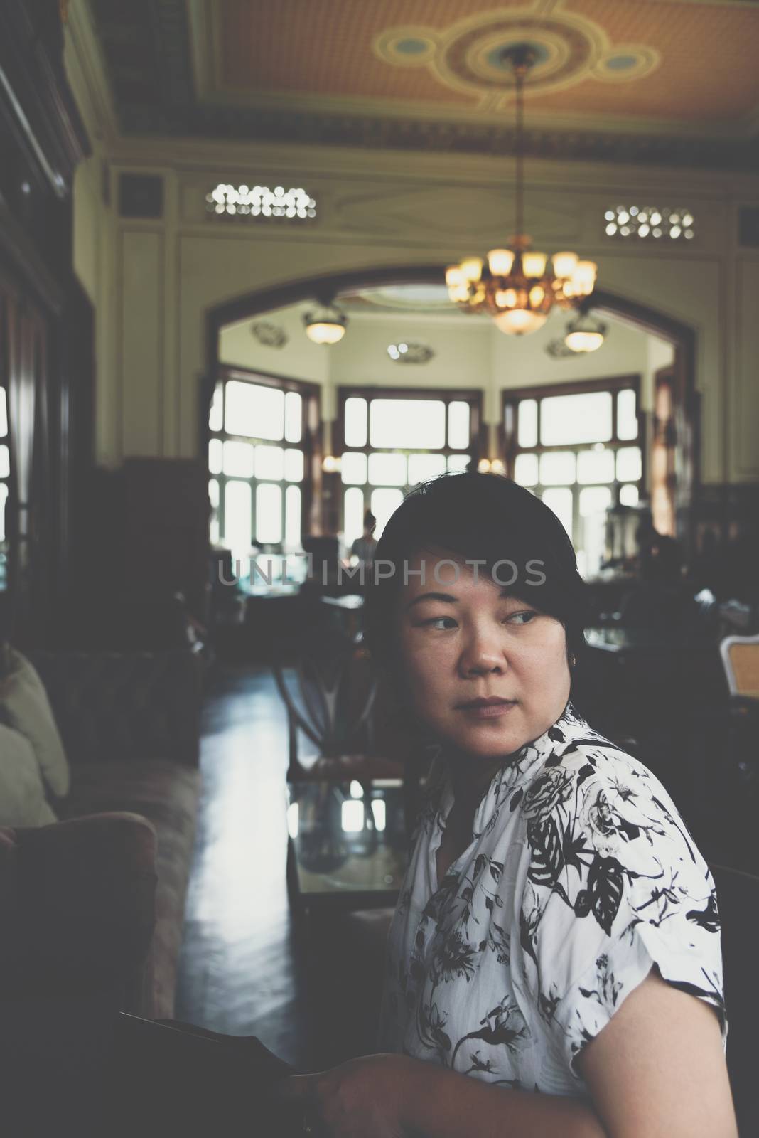 Asia women 40s white skin in white and black dress have a lovely smart smile gesture in a coffee shop cafe vintage style