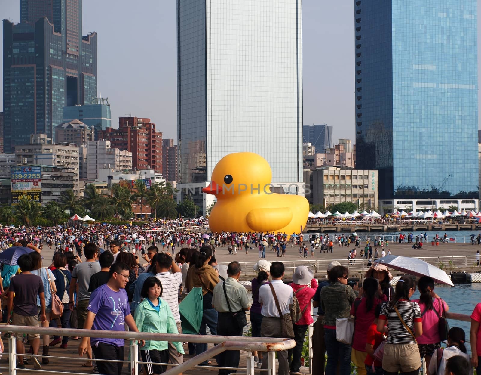 KAOHSIUNG, TAIWAN -- SEPTEMBER 28: Visitors flock to see the giant rubber duck designed by Dutch artist Hofman while it is on display at the Glory Pier on September 28, 2013 in Kaohsiung