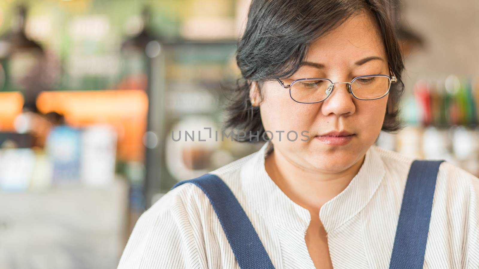 Asian woman 40s white skin plump body with backpack and jacket waiting in department store or shopping mall