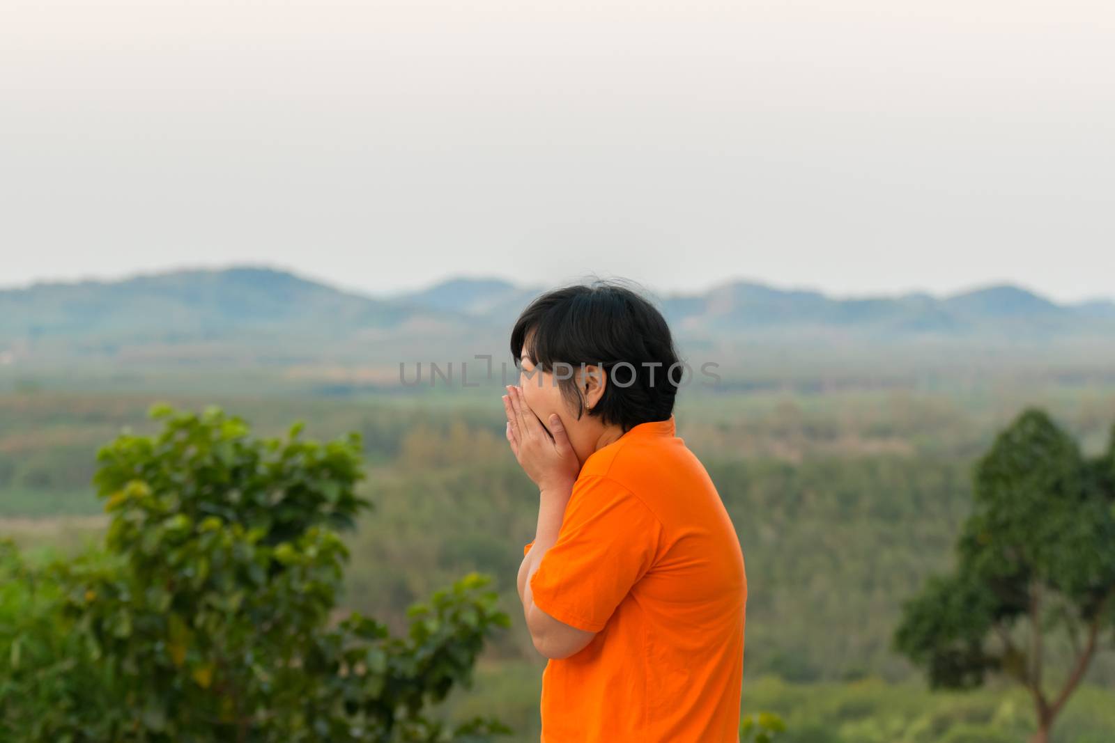 Asia woman plump body in orange T-shirt posing and scared at mountain view when travel