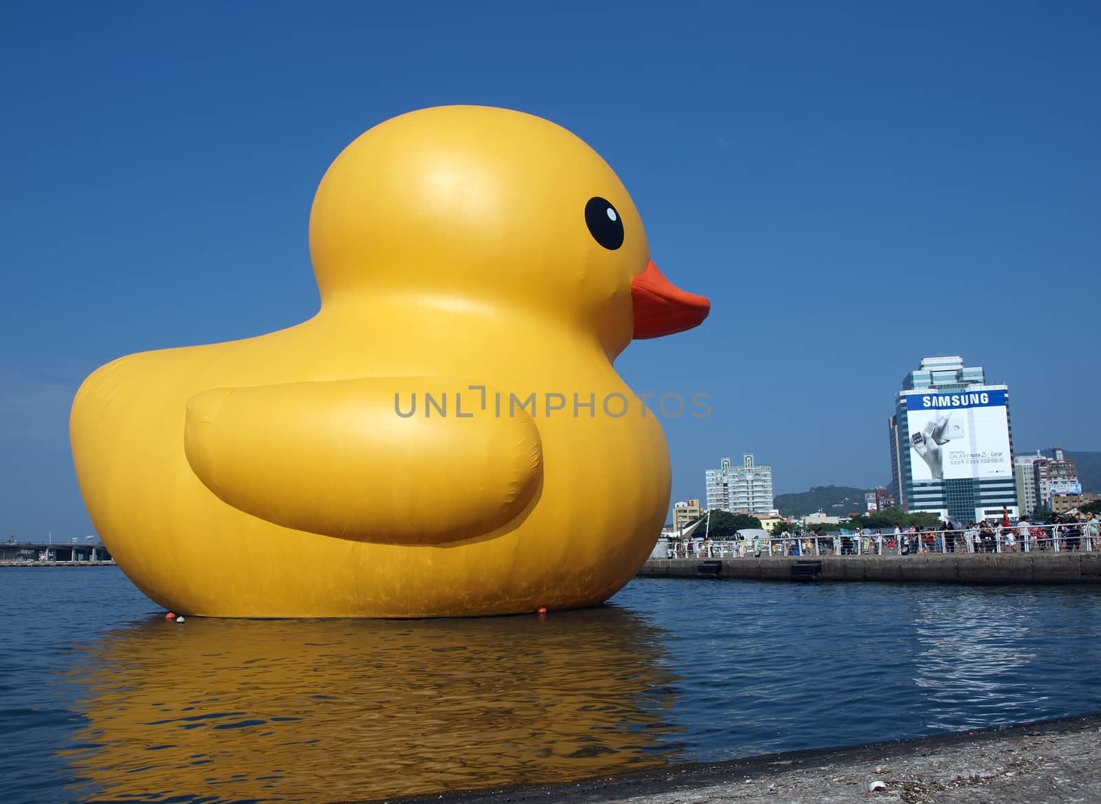 KAOHSIUNG, TAIWAN -- SEPTEMBER 29: Visitors flock to see the giant rubber duck designed by Dutch artist Hofman while it is on display at the Glory Pier on September 29, 2013 in Kaohsiung