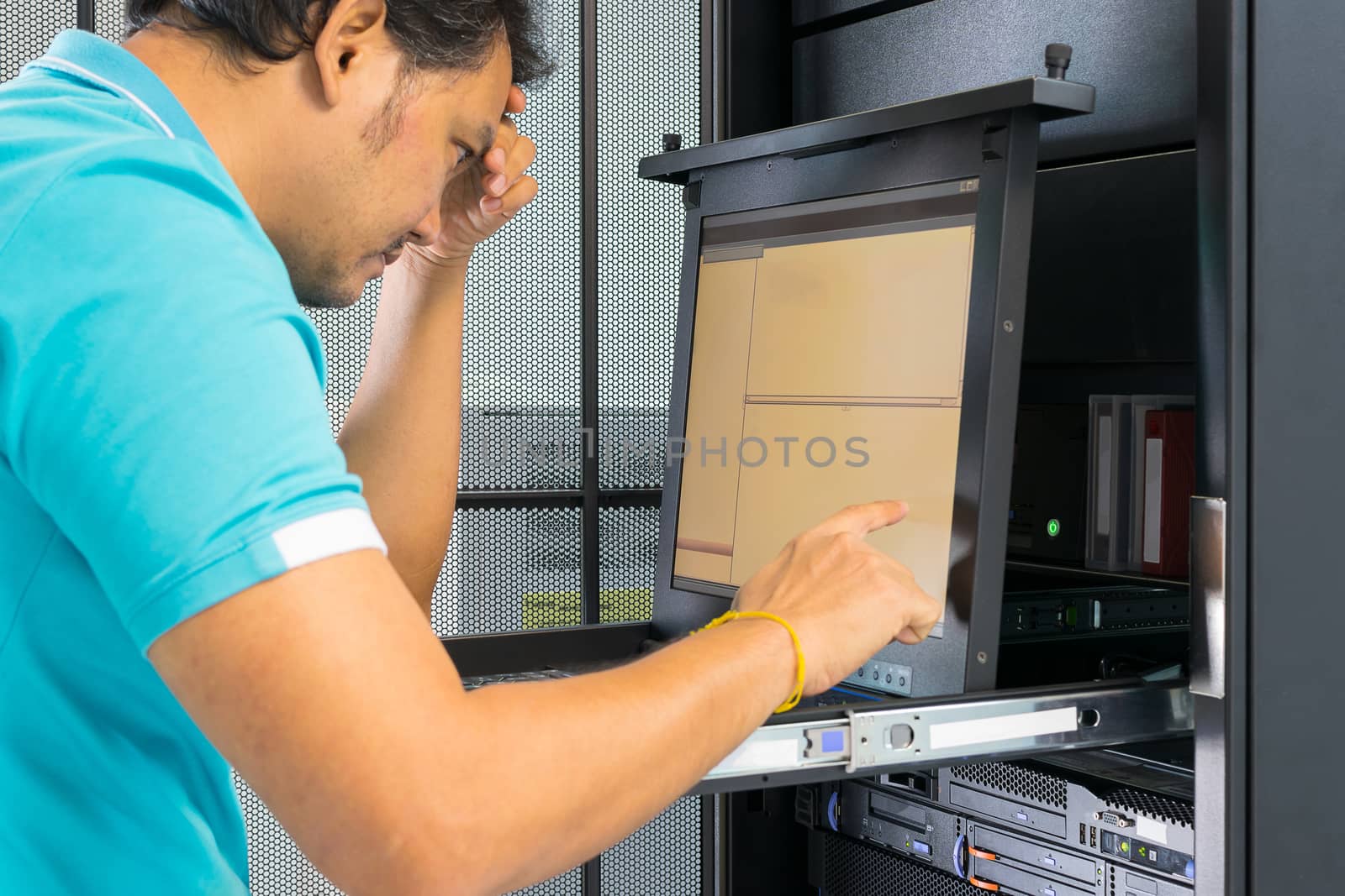 Asia man serious thinking when working on computer server