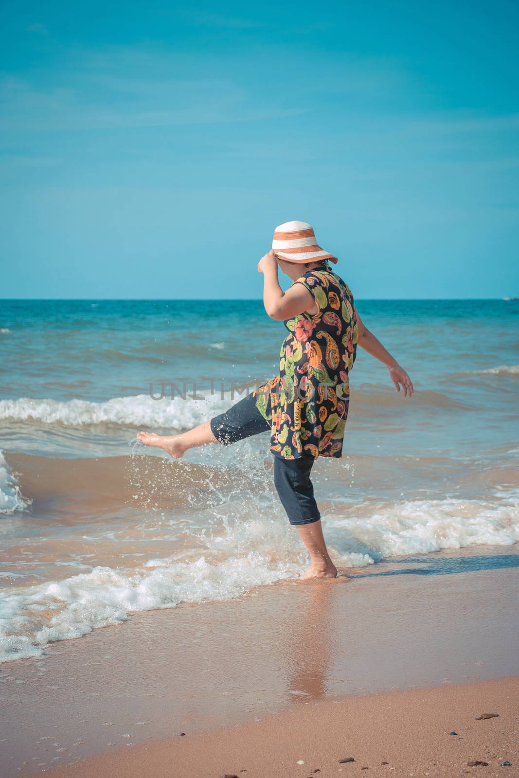 Asia woman plump body in colorful dress with hat posing at beach with blue sea and sky when travel , process in vintage style