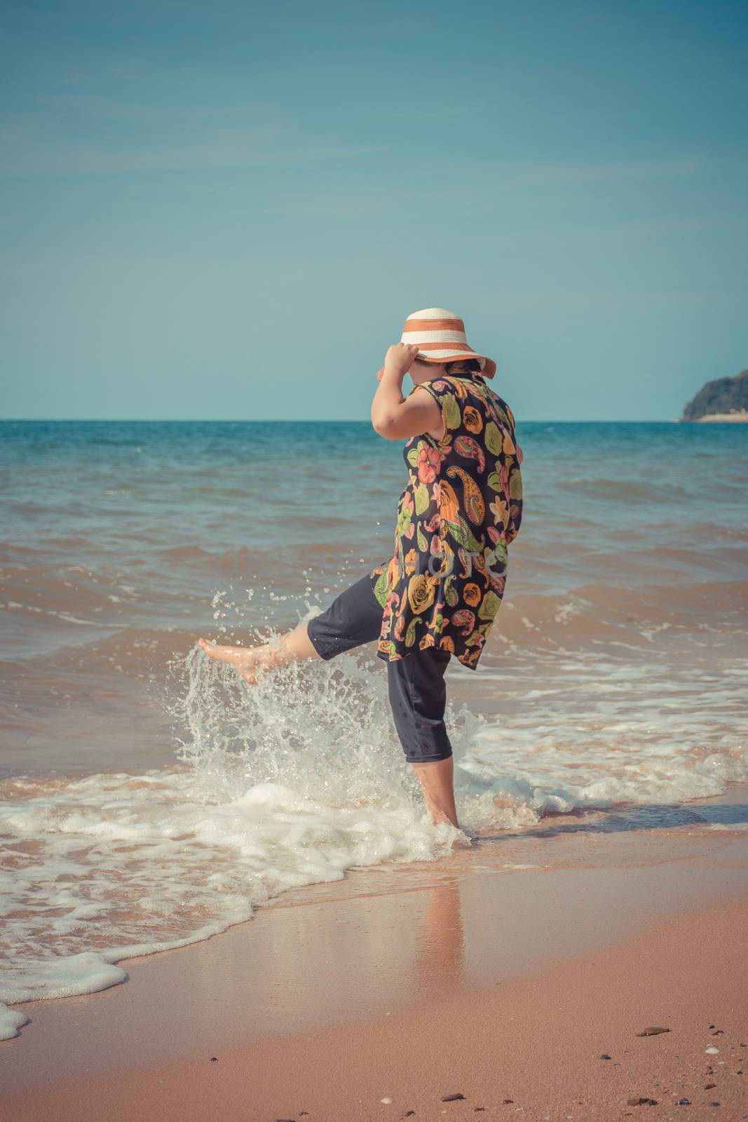 Asia woman plump body in colorful dress with hat posing at beach with blue sea and sky when travel , process in vintage style