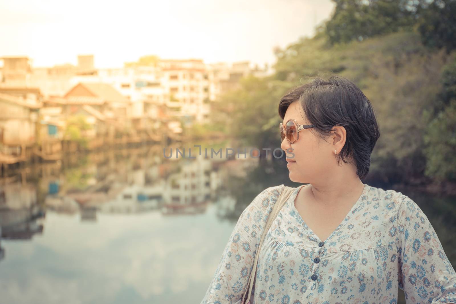 Asia woman plump body with sunglasses standing at river side when travel , process in vintage style