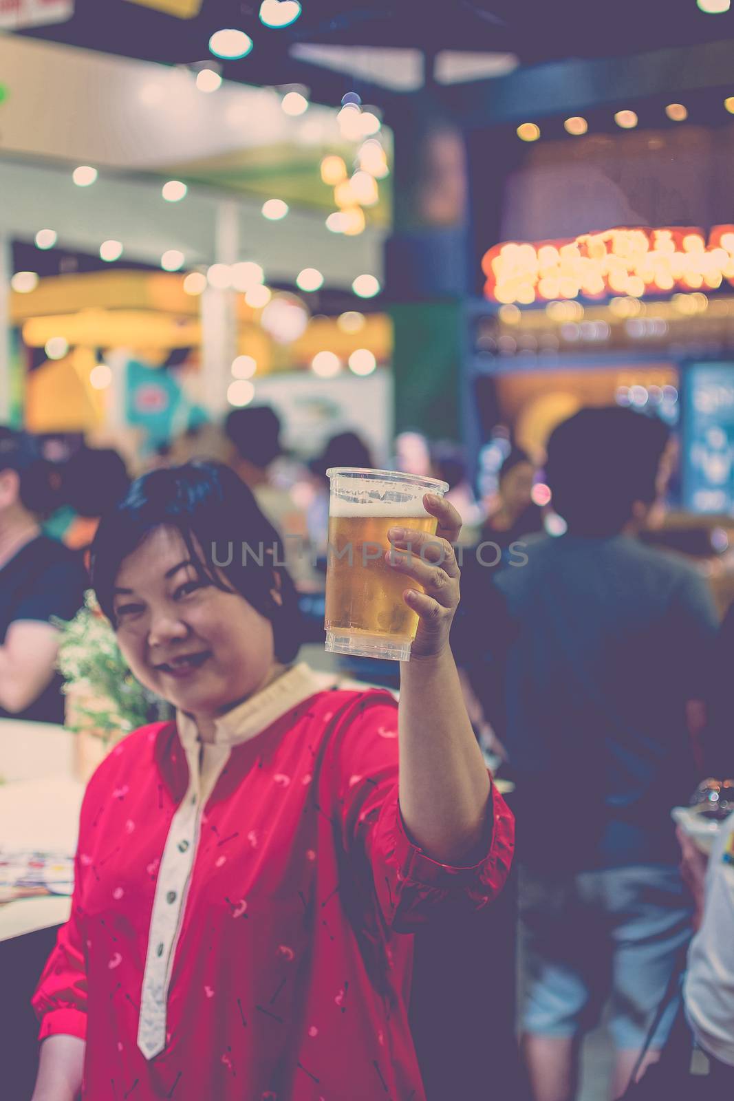 Asia woman plump body have fun holding a beer in pub with indoor party , process in vintage style