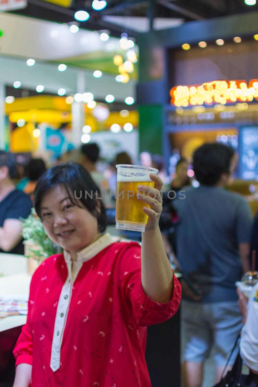 Asia woman plump body have fun holding a beer in pub with indoor party