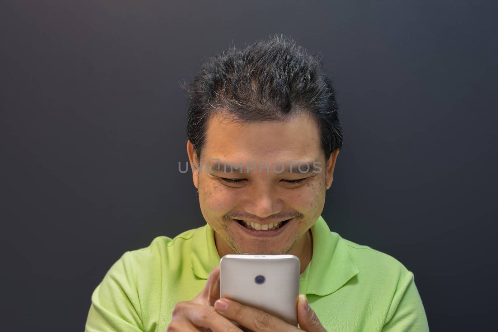 Asia man happy and smiling using smartphone on black background