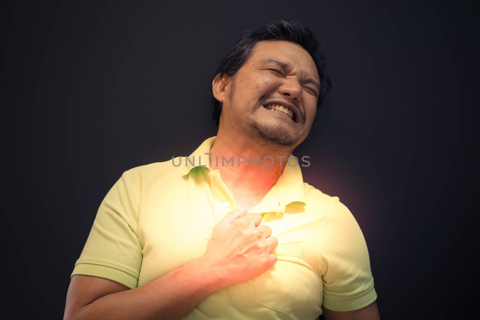Asia man pain from disease heart attack in black background , process in dark and alert style
