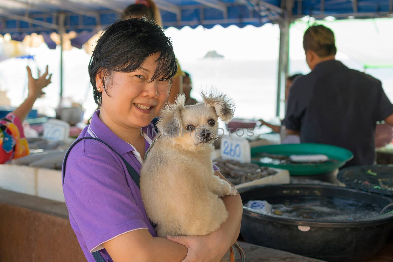 Asia woman and her pet shopping Thai seafood market at Laem Mae Phim Beach on Kram, Klaeng, Rayong, Thailand.