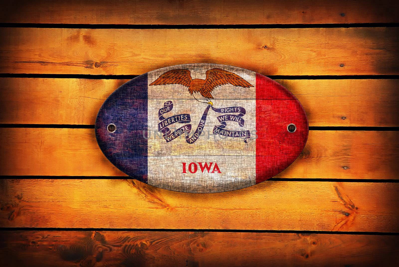 A Iowa flag on brown wooden planks.