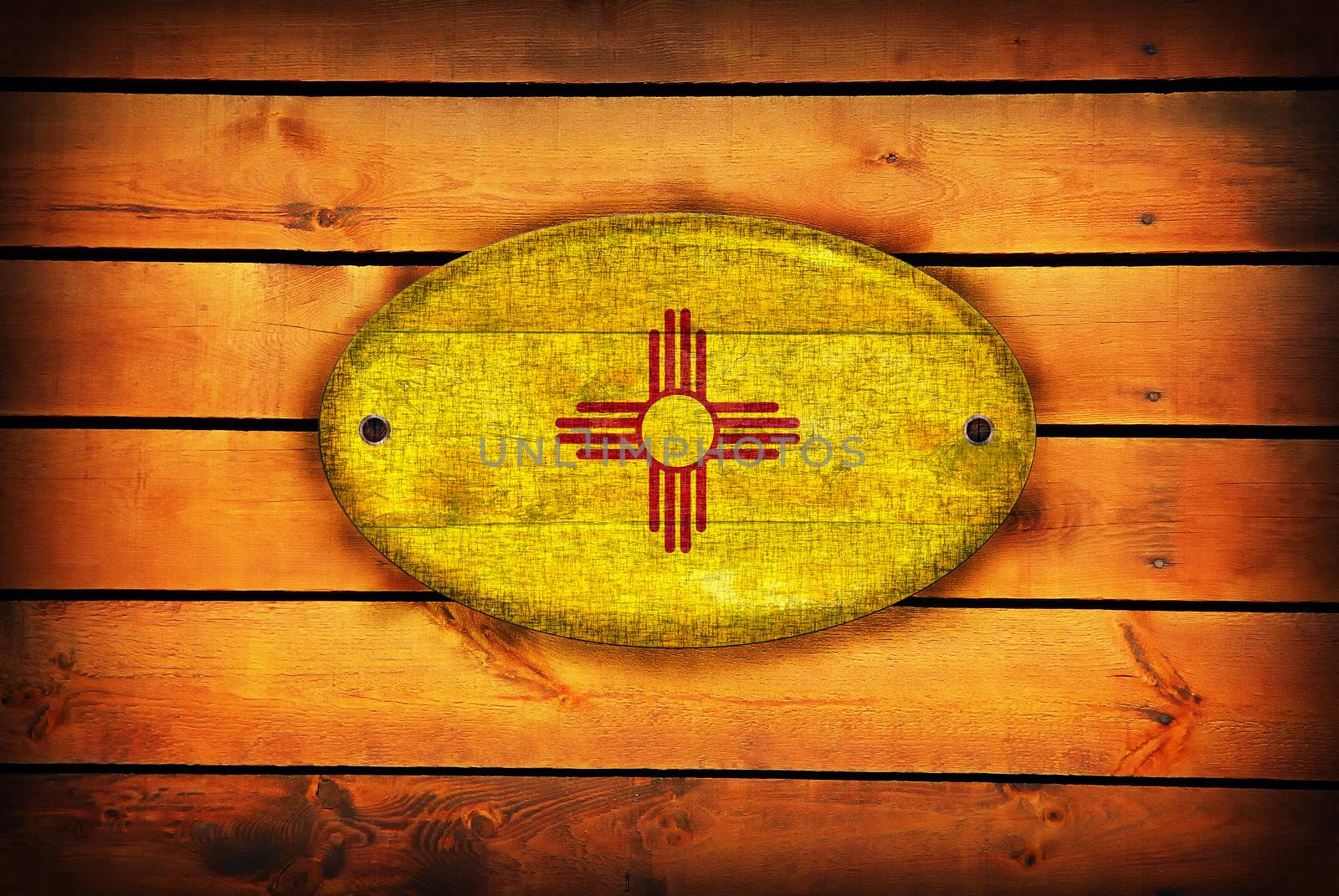 A New Mexico flag on brown wooden planks.