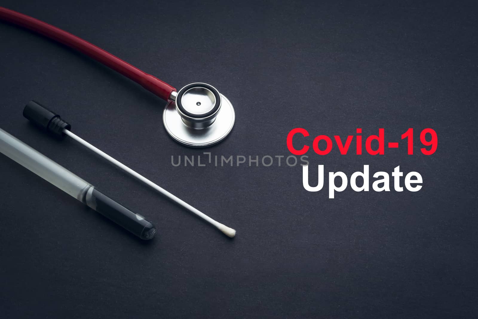 COVID-19 or CORONAVIRUS UPDATE text with stethoscope and medical swab on black background by silverwings