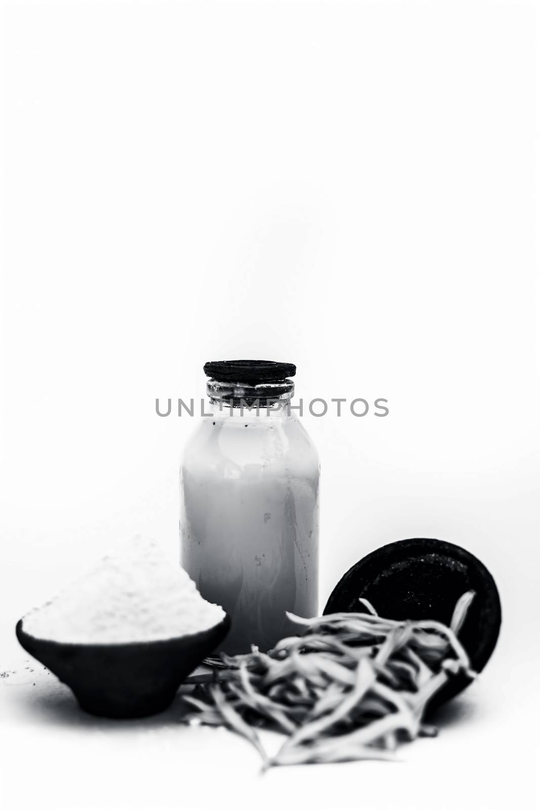 Popular Indian &amp; Asian ayurvedic herb isolated on white in a clay bowl i.e. Musli or safed musli or Chlorophytum borivilianum with its powder in a clay bowl and raw milk in a transparent glass bottle.